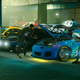 People hanging out in a warehouse filled with cool cars in GTA Online.